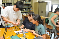 生徒から電子回路の仕組みを教わる親子